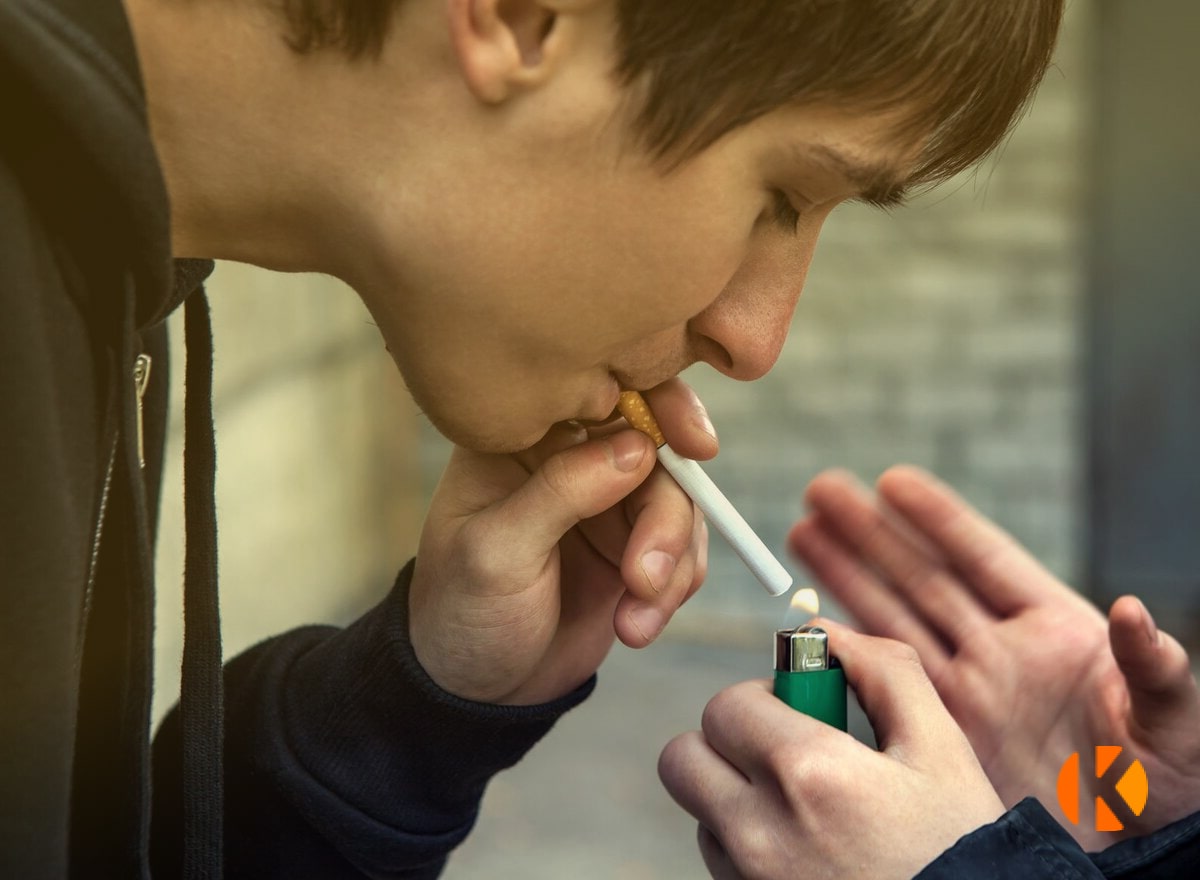 Человек подкуривает сигарету