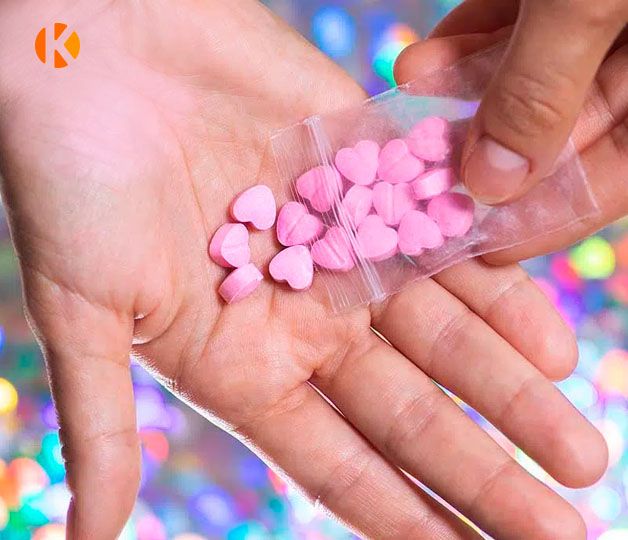 Розовые таблетки экстази на ладони