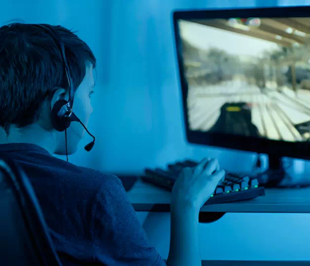 Подросток играет в компьютер